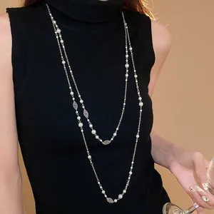 Vintage long faux pearl sweater chain with delicate silver flower charms on model