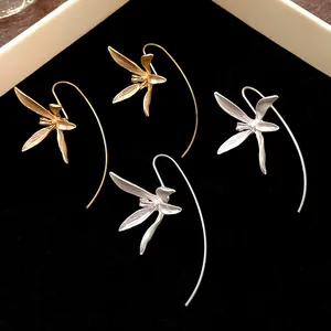 Primo piano di eleganti orecchini a gancio con iris vintage in finitura oro e argento opaco