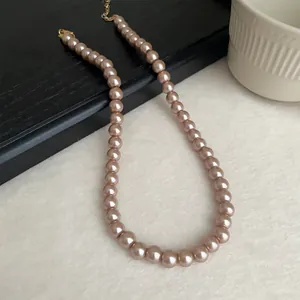 Close-up view of an elegant champagne pearl necklace with a golden clasp adornment