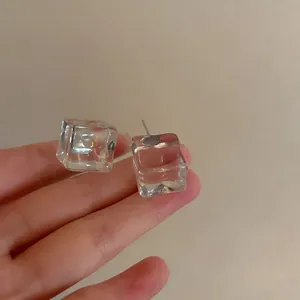 Detailed view of minimalist transparent ice cube stud earrings with premium silver needles