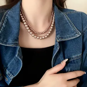 Close-up of elegant double-layered champagne pearl necklace worn with denim jacket