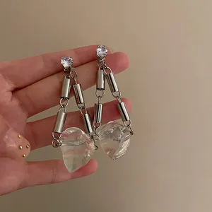Detailed macro view of silver needle transparent irregular ice cube drop earrings