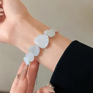 Close-up of elegant iridescent heart-shaped bracelet with shell texture detail