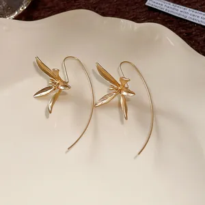Dettaglio macro di orecchini a gancio con iris dorato vintage dal design minimalista