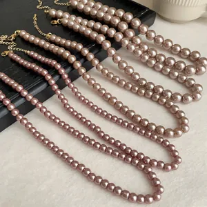 Detailed close-up view of multiple elegant pink pearl necklaces with gold-tone clasps