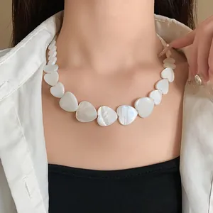 Close-up detail of irregular heart-shaped shell necklace on model
