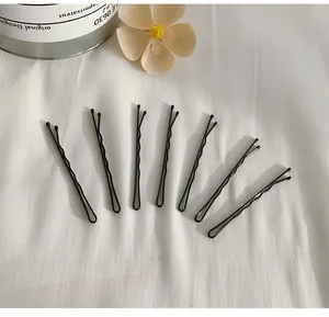 Set di forcine per capelli ondulate nere minimaliste su tessuto bianco