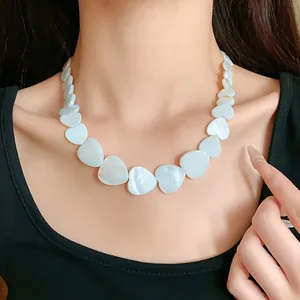 Detail shot of a minimalist irregular heart-shaped shell necklace on model's neck