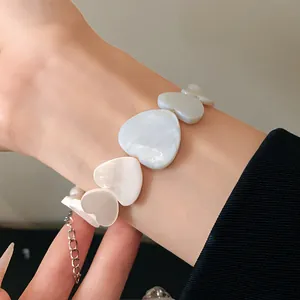 Close-up of elegant irregular heart-shaped necklace with pearlescent shell texture.