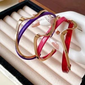 Brazaletes abiertos de ondas de acrílico chapados en oro en colores muy vibrantes