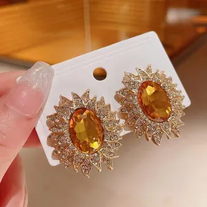 Orecchini a lobo a girasole dorati con grande cristallo ambra e cornice di strass