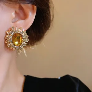 Orecchini a perno a girasole dorati con gemma ambra e strass scintillanti