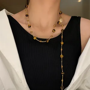 Vintage tiger eye beaded long necklace worn over a black sweater for autumn winter