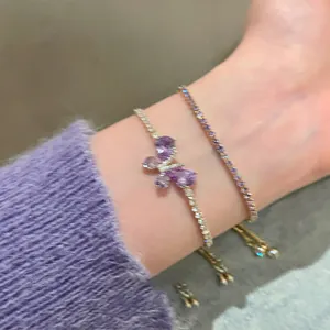 Detailed close-up of a Korean style zircon butterfly bracelet and purple tennis chain on a wrist.