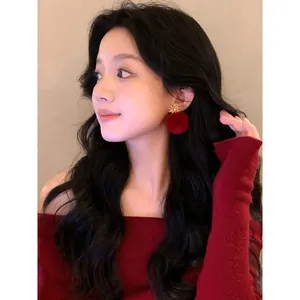 Model wearing elegant red flocked flower stud earrings for autumn and winter outfits.