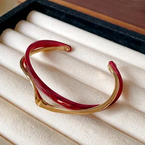 Detalle de una pulsera abierta de doble capa de acrílico burdeos y chapado en oro