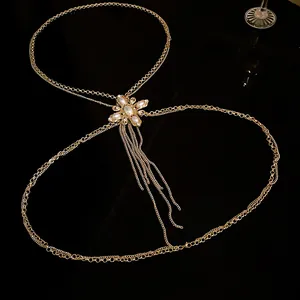 Elegant gold body chain with pearl flower and rhinestone tassels on black background