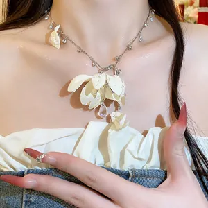 Close-up view of elegant fabric flower necklace with rhinestone teardrop pendant on a model