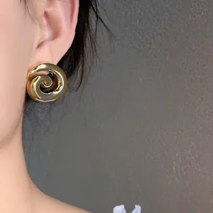 Elegant gold glossy spiral geometric stud earrings featuring a vintage minimalist design