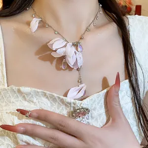 Detailed view of pink fabric flower necklace with sparkling teardrop crystals on model