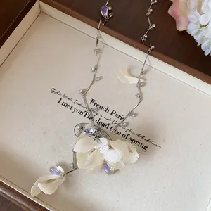 Detail view of a dainty necklace with fabric flower petals and rhinestone drops