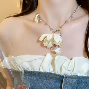 Close-up detail of a light luxury fabric flower necklace with crystal water drop pendant