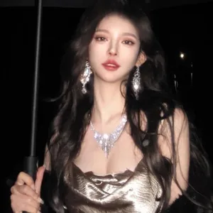 Detail view of sparkly rhinestone tassel earrings worn by a model in a night setting