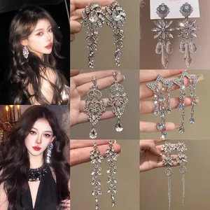 Macro view of silver tassel earrings with sparkling crystals and elegant model showcase detail