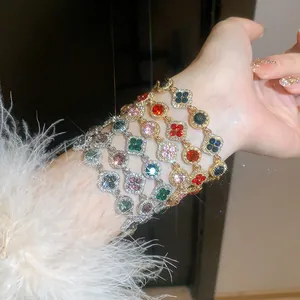 Detailed view of luxury multi-colored rhinestone flower clover charm bracelets on a wrist