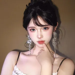 Close-up view of sparkling crystal flower tassel earrings worn by a model for elegant look.