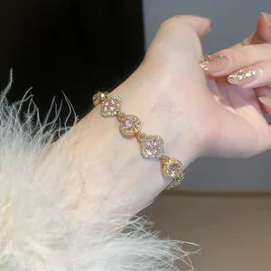 Close-up of elegant Korean style gold bracelet with pink flower and round crystals