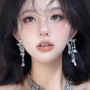 Close-up detail of luxury silver needle earrings featuring shimmering rhinestone tassels