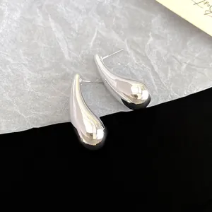 Close-up detail showing the glossy silver teardrop finish of these geometric stud earrings