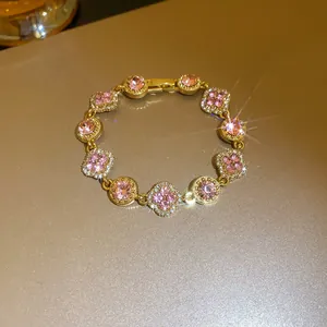 Detailed shot of an elegant pink gemstone and gold flower bracelet with sparkles