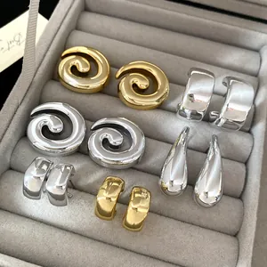 Detailed view of vintage gold and silver geometric earrings set in a grey jewelry box.