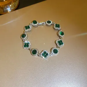 Detailed view of elegant flower and round crystal bracelet with emerald green gemstones