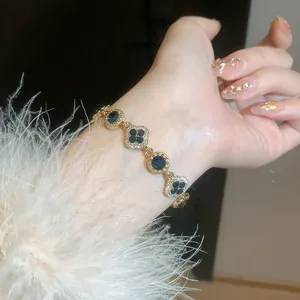 Detailed view of a gold-plated bracelet featuring diamond-encrusted clover and round motifs.