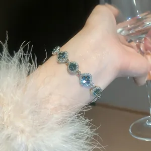 Exquisite silver-toned sparkling flower and round link bracelet worn on woman wrist