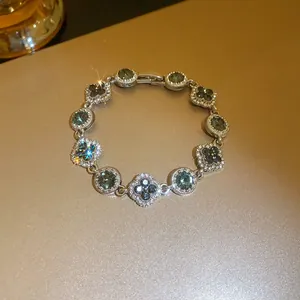 Close-up detail of an elegant flower and round crystal bracelet with dark stones and sparkle