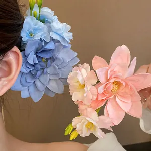 Detailansicht von blauen und rosa Stoffblumen-Haarspangen an einem Modell