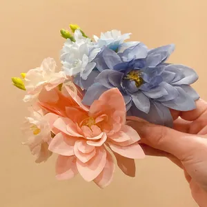 Detaillierte Makroansicht einer handgefertigten Stoffblumen-Haarklammer in Blau und Pfirsich