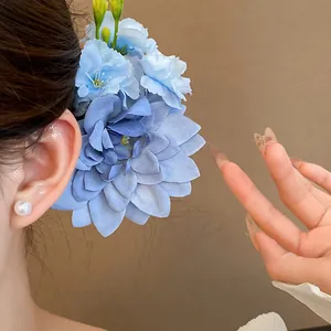Detailansicht einer eleganten blauen Stoffblumen-Haarspange an einem Mode-Model