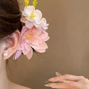 Nahaufnahme einer eleganten rosa Stoffblumen-Haarspange, die im Haar eines Models getragen wird