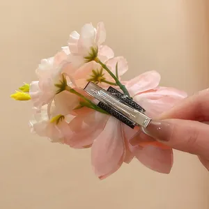 Detailansicht der Rückseite einer rosa Stoffblumen-Haarspange mit silbernem Metallclip