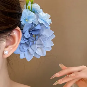 Nahaufnahme einer blauen Stoffblumen-Haarklammer, ideal für den süßen Strandurlaub.