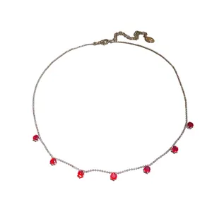 Collier élégant de couleur argent avec plusieurs pierres de zircon rouge pendantes.