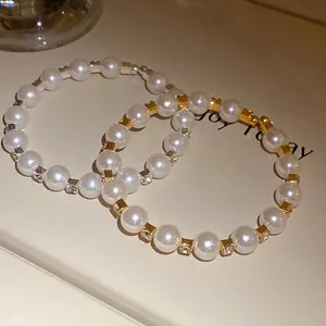 Elegant pearl beaded bracelets with gold spacers and sparkling rhinestones in a warm setting.