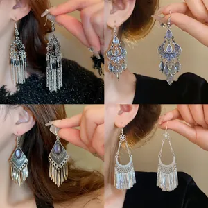 Detailed views of ethnic silver tassel earrings set in bohemian vintage style