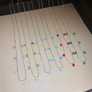 Gros plan de colliers en chaîne à billes avec pendentifs ronds en zircone multicolore
