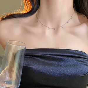 Gros plan d'un ras de cou en argent minimaliste avec des pendentifs en zircon sur un mannequin.